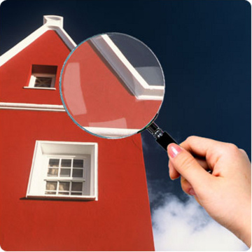 Looking at house through magnifying glass